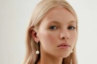 minimalist bridal earrings with gold hoops and regular pearls hanging on thin bars look very chic and stylish