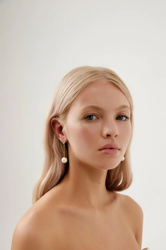 minimalist bridal earrings with gold hoops and regular pearls hanging on thin bars look very chic and stylish