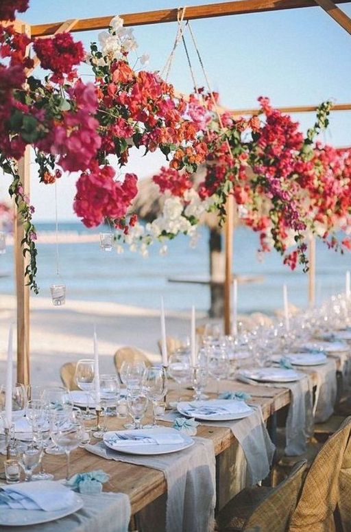 overhead floral installations of bougainvillea and white blooms plus greenery is a gorgeous idea for a Mediterranean wedding