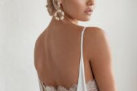 statement baroque pearl earrings and matching pearl buttons accenting the back of the wedding dress
