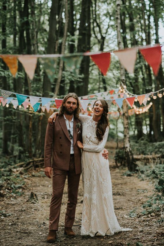 a boho groom's look with a brown pantsuit, a white shirt, black shoes and sunglasses is cool