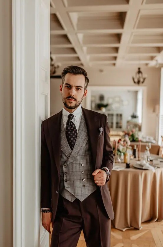 a brown pantsuit, a grey plaid waistcoat, a black printed tie, a white shirt are a perfect combo for a fall wedding