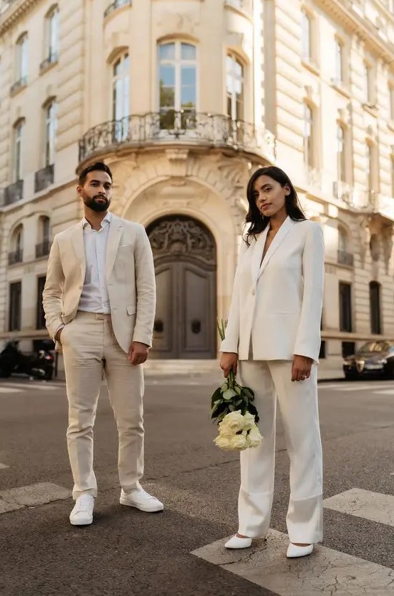 a neutral groom's look with a tan pantsuit, a white shirt and white sneakers is a great idea for a neutral wedding