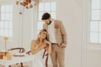 26 a tan checked pantsuit, a white shirt, brown boots and a bold boutonniere are a cool combo for a boho groom’s look