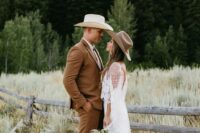 a cowboy groom’s outfit with a brown pantsuit, brown boots, a hat and a bolo tie is cool for a rustic wedding