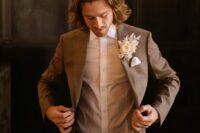 31 a modern groom’s outfit with a brown pantsuit, a white shirt, a white dried flower boutonniere is very elegant