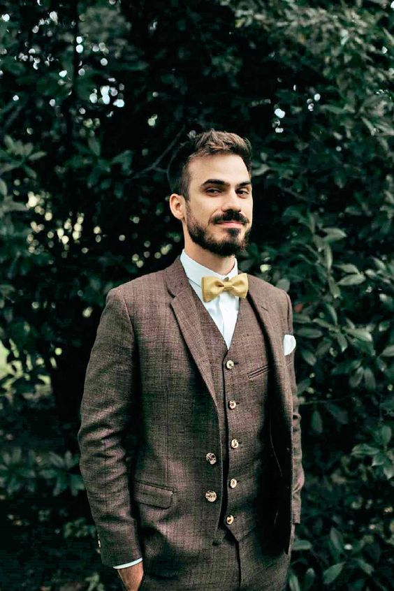 a simple and elegant groom's outfit with a brown three-piece pantsuit, a white shirt, a yellow bow tie is easy to repeat