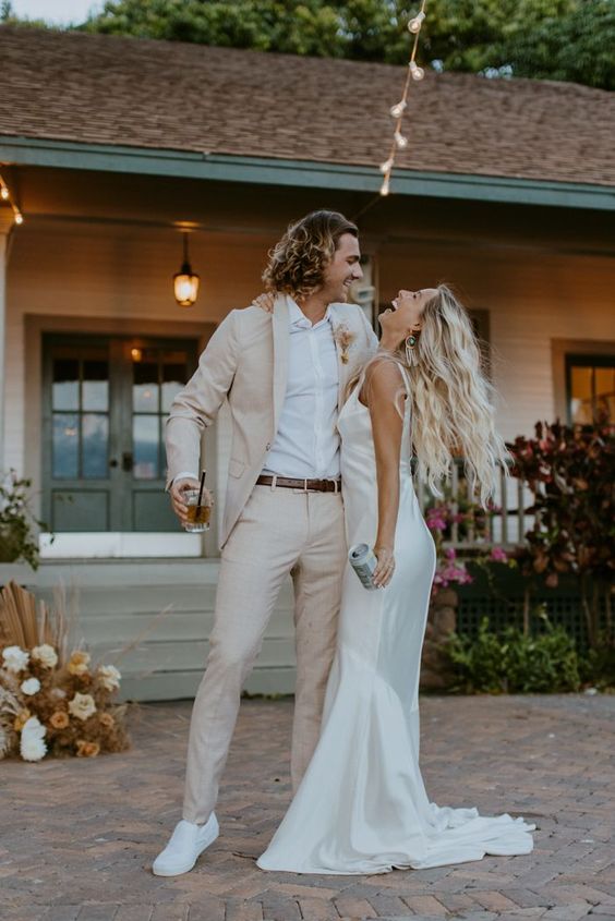 a tan pantsuit, a white shirt, white sneakers and a brown belt are super cool for a relaxed modern groom's look