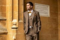 41 a vintage-inspired groom’s look with a brown three-piece pantsuit, a white shirt, a rust-colored bow tie and shoes, a handkerchief