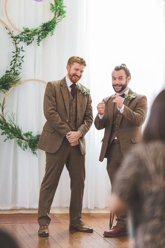brown three-piece pantsuits, white shirts, brugundy ties, brown shoes and boutonnieres for matching looks of both grooms