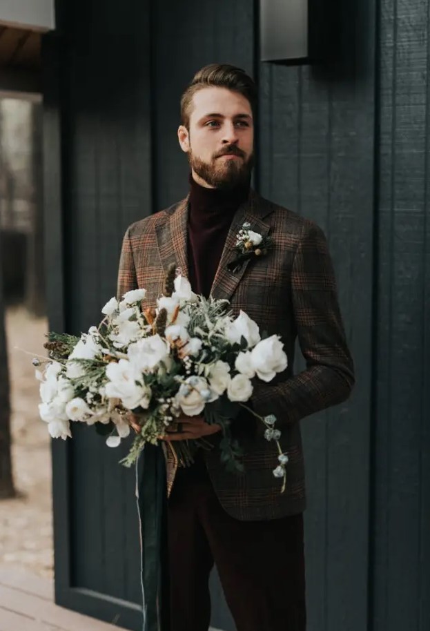 brown velvet pants and a matching turtleneck, a brown plaid blazer and a boutonniere for a casual winter groom's look