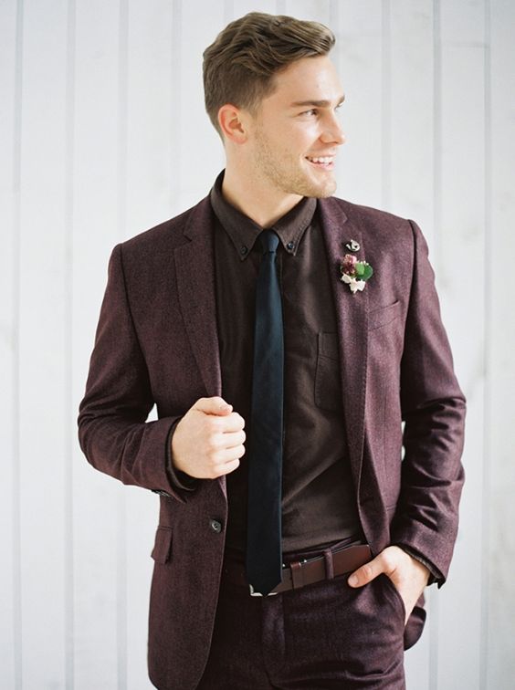 a beautiful moody groom's look with a purple suit, a matching shirt, a black tie and a brown belt