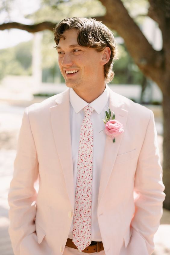 a blush pantsuit, a white shirt, a bright printed tie, a pink boutonniere are a cool combo for a spring wedding with soft touches of color