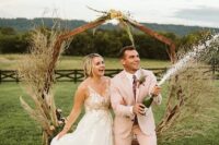 a blush pantsuit, a white shirt, a floral tie and brown shoes are a great combo for a boho wedding