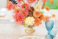a bold wedding centerpiece of an urn with pink, orange, peachy adnd yellow dahlias is a cool idea for summer or fall