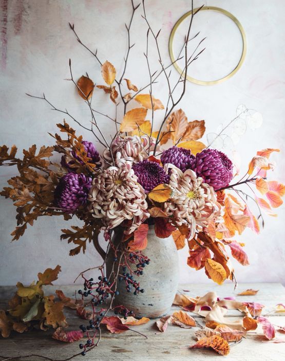 a bright fall wedding centerpiece of blush and fuchsia mums and bright fall foliage looks really breathtaking and very fall-like