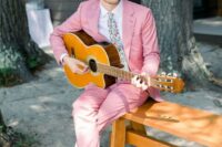 a bright groom’s look with a bright pink pantsuit, a white shirt, a colorful tie, amber shoes is a cool solution for a boho wedding
