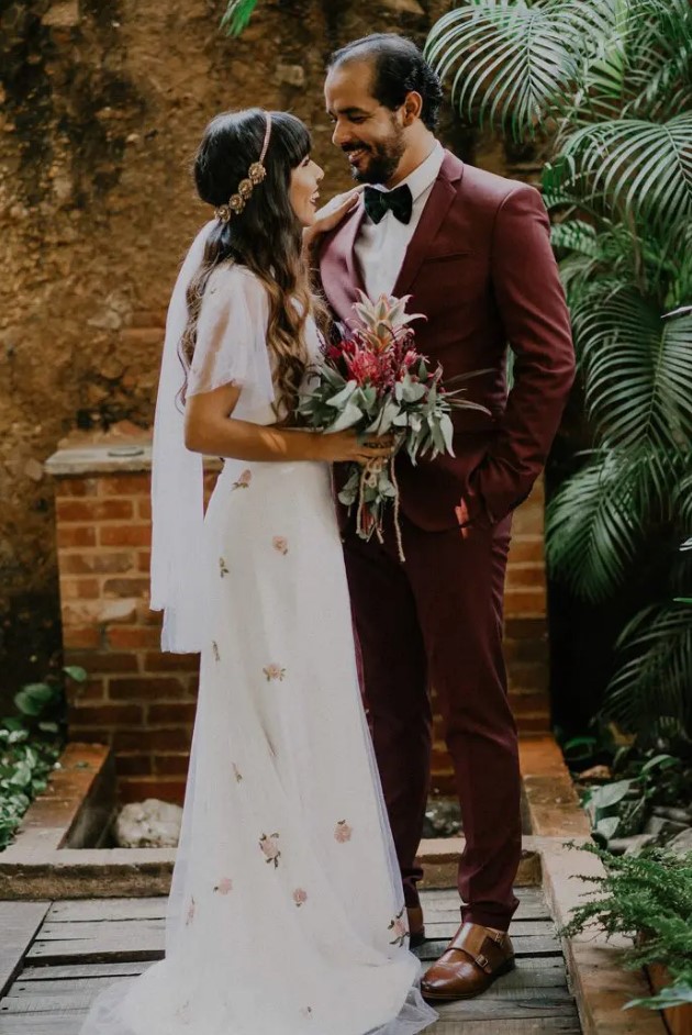a burgundy suit, a black velvet bow tie, amber-colored shoes for a tropical groom's look with a twist