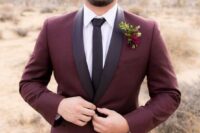 a burgundy tuxedo with black lapels, a white shirt and a black tie plus a bold floral boutonniere for a fall groom