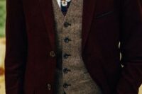 a burgundy velvet groom’s suit with a tweed waistcoat, a moody floral tie for a fall groom’s outfit