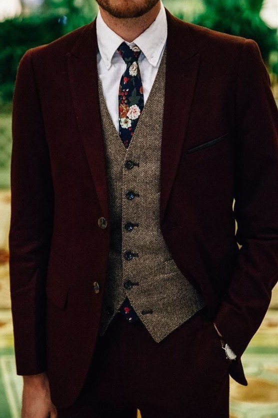 a burgundy velvet groom's suit with a tweed waistcoat, a moody floral tie for a fall groom's outfit