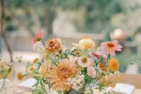 a catchy summer wedding centerpiece of yellow and pale rust dahlias, pink and neutral fillers and greenery