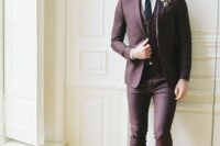 a chic and modern groom’s look with a purple three-piece suit, a white shirt, a black tie and brown shoes