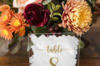 a chic fall wedding centerpiece of yellow mums, orange, burgundy and blush blooms and greenery is a catchy idea