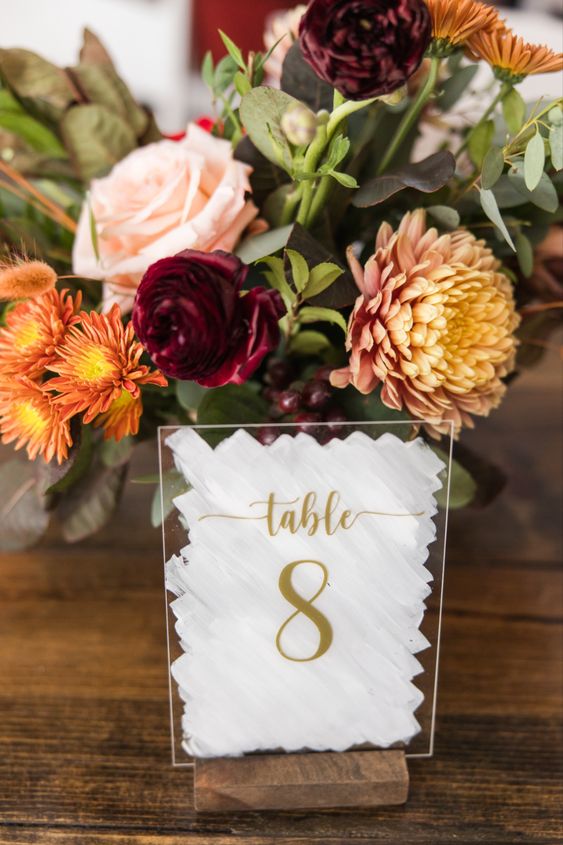 a chic fall wedding centerpiece of yellow mums, orange, burgundy and blush blooms and greenery is a catchy idea