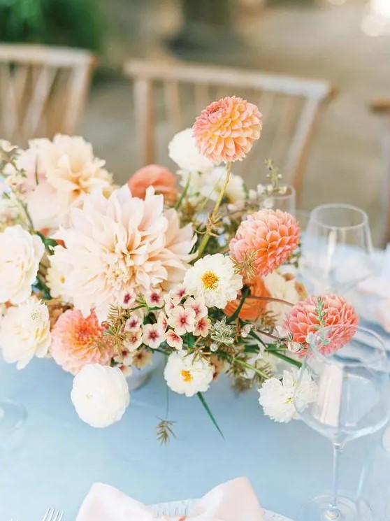 a chic summer wedding centerpiece of blush, coral and white dahlias, fillers and greenery is a cool idea