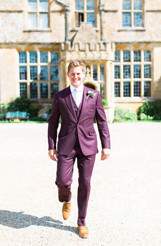 a cool and bright purple three-piece pantsuit, a white shirt and a white tie, amber shoes and a boutonniere