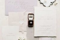 a delicate and refined neutral wedding invitation suite with lilac and gray pieces, a raw edge and calligraphy is amazing