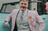 a delicate and whimsy groom’s look with a blush pantsuit, a grey waistcoat, a white shirt, a bright floral tie and a handkerchief