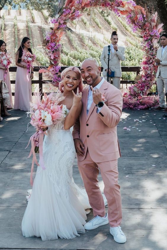 a dusty pink pantsuit with an oversized blazer, a white shirt, white sneakers are a lovely combo for a modern wedding with lots of pink