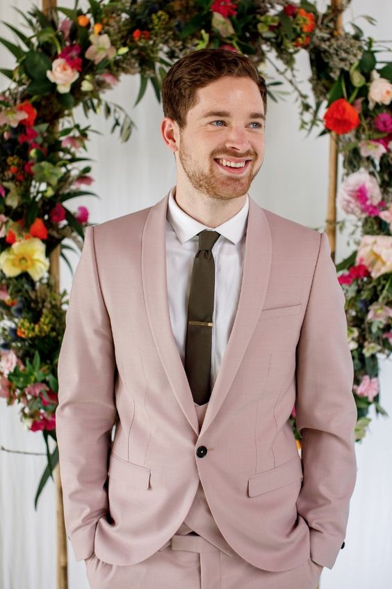 a dusty pink three-piece pantsuit, a white shirt, an olive green tie are a lovely combo for a summer wedding