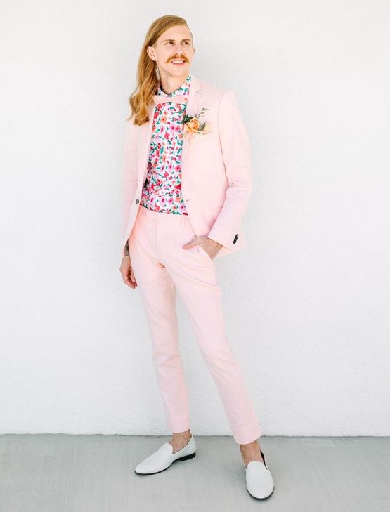 a fun pink groom's suit, a bright floral shirt, a pink bow tie and white moccasins for a whimsy wedding