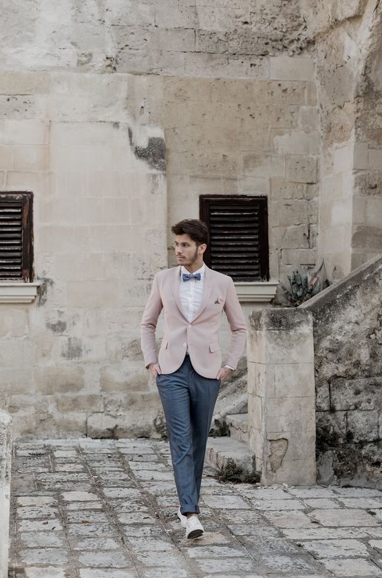 a gorgeous groom's look with graphite grey pants and a bow tie, a white shirt, a pink jacket and neutral shoes