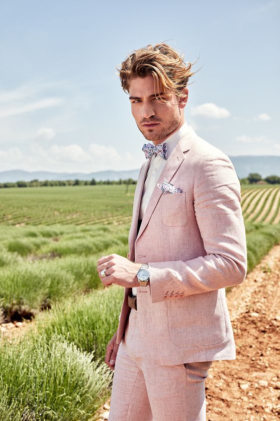 a light pik groom's suit with a white shirt, a floral bow tie and a handkerchief are a great look for a spring wedding