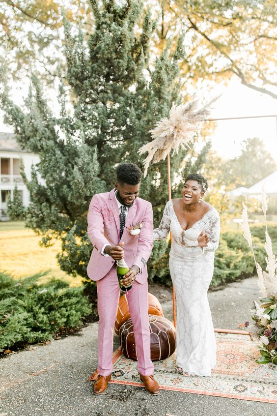 a light pink pantsuit, a white shirt, a checked tie and amber shoes are a lovely combo for a summer wedding