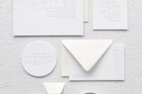 a minimalist all-white letterpressed invitation suite is a unique and very eye-catchy idea