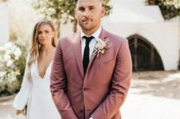 a modern groom’s outfit with a white shirt, a mauve blazer, a black tie and pants, a blush rose boutonniere