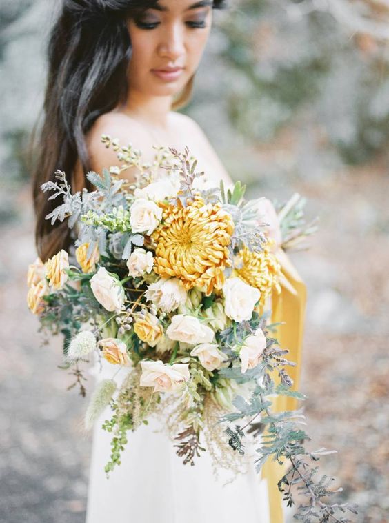 a pale fall wedding bouquet of blush and mustard roses, mustard chrysanthemums and pale leaves is amazing