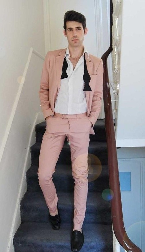a pink suit, a white shirt, black shoes and a black bow tie for a fresh and cool summer groom's outfit