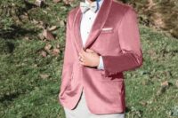 a refined groom’s look with grey trousers and a bow tie, a pink velvet blazer, a white shirt with black buttons