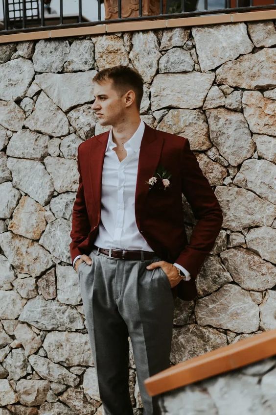 a relaxed groom's look with a burgundy blazer, grey trousers, a white shirt, a brown belt is great for a more casual wedding