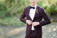 a simple and very refined groom’s look with a purple pantsuit, a white shirt, a black bow tie and a belt