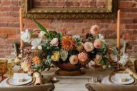 a sophisticated fall wedding centerpiece of blush mums, rust dahlias, white and yellow blooms and greenery is adorable