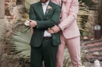 a stylish pink groom’s look with a light pink pantsuit, a floral shirt, black loafers and a pink boutonniere