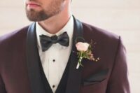 a stylish take on a tuxedo look – a burgundy tux with black lapels and a black vest