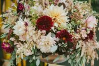 a super lush wedding arrangement of neutral and burgundy blooms, eucalyptus and some foliage for a summer or fall wedding
